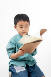 男孩在白色背景下拿着作业本