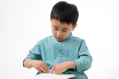 男孩在白色背景下拿着作业本