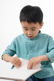 男孩在白色背景下拿着作业本