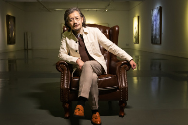 画廊内的老艺术家坐在沙发上