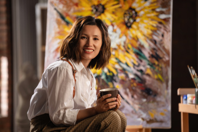 工作室内拿着杯子的青年画家