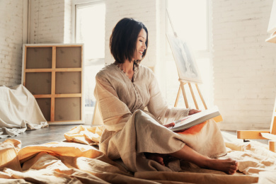 工作室内坐在地上看书的青年画家