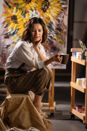 工作室内拿着杯子的青年画家