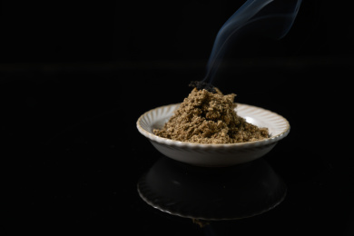 桌面上的盘子里点燃的艾草绒