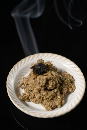 桌面上的盘子里点燃的艾草绒