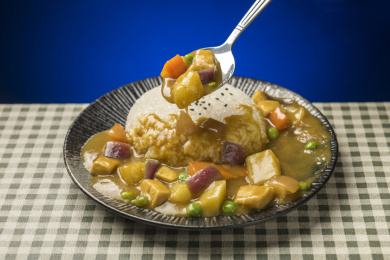 一盘咖喱鸡肉饭摆放在桌面上特写