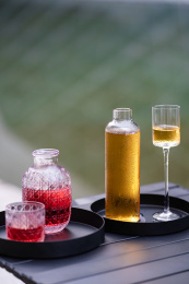 湖边木桌上摆放的酒具茶具果酒