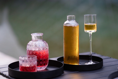 湖边木桌上摆放的酒具茶具果酒