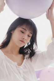 年轻女人在床上举着气球