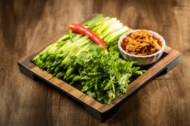 棕色木纹桌面上放着一盘鸡蛋酱蘸小葱