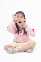 坐在地上做搞怪表情的小女孩