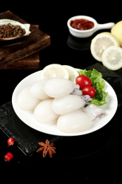 黑底上摆放着一盘新鲜墨鱼仔