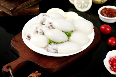 木板上一盘新鲜墨鱼仔