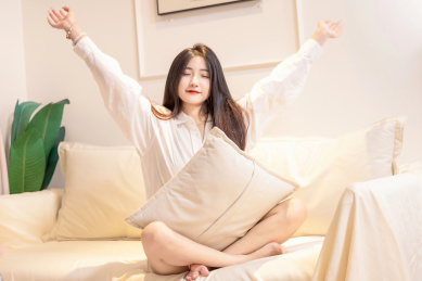 一名美女抱着枕头坐在沙发上