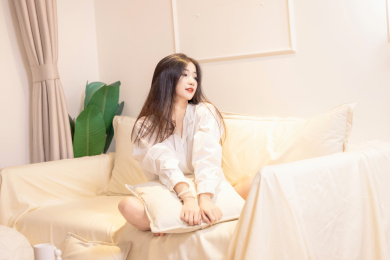 一名美女抱着枕头坐在沙发上