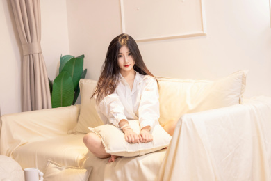 一名美女抱着枕头坐在沙发上
