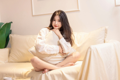 一名美女抱着枕头坐在沙发上