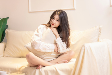 一名美女抱着枕头坐在沙发上