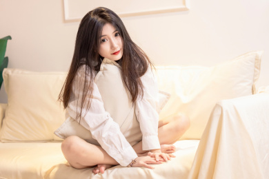 一名美女抱着枕头坐在沙发上