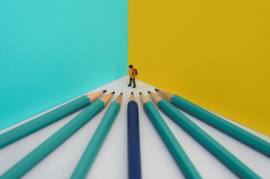 被铅笔围困在墙脚的上学儿童微缩创意图