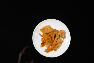桌面上的盘子里的美味可口的凉拌莲藕片