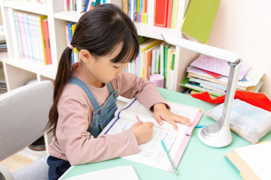 室内低头写家庭作业的小学生