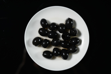 桌面上的盘子里的美味可口的黑橄榄