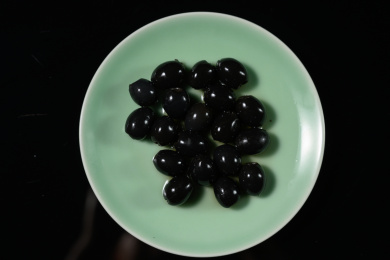 桌面上的盘子里的美味可口的黑橄榄