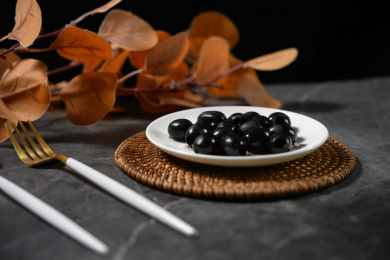 桌面上的盘子里的美味可口的黑橄榄