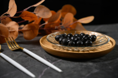 桌面上的盘子里的美味可口的黑橄榄