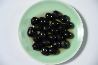 桌面上的盘子里的美味可口的黑橄榄