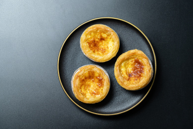 一盘美味的蛋挞放在黑色背景上