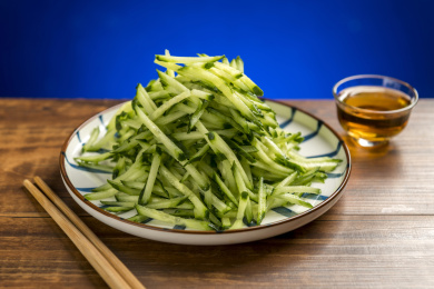 一盘黄瓜丝摆放在木桌面上特写