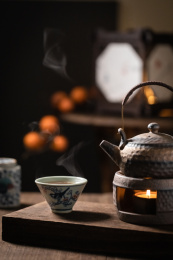 木桌上正在煮着茶的茶壶和热茶