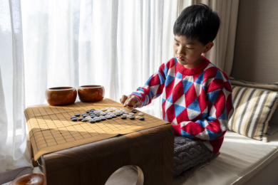 中国小孩在窗边下棋围棋