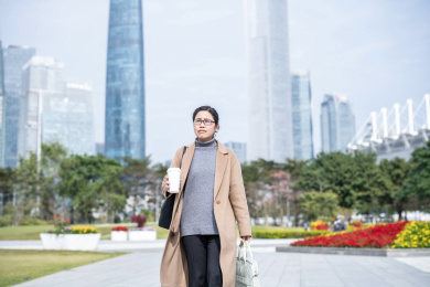 城市中心端着咖啡去上班的职业女性   