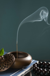 正在香炉中焚烧的沉香线香特写深色调
