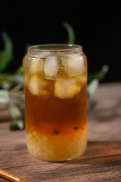 桌面上的杯子里的美味可口的冰蜜桃乌龙茶