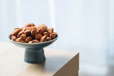 一盘巴旦木放在红色高足盘中