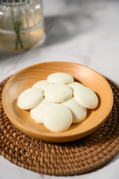 桌面上的盘子里的美味可口的白巧克力币