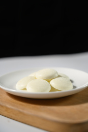 桌面上的盘子里的美味可口的白巧克力币