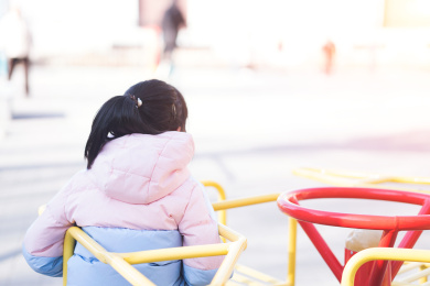 独自一人的小姑娘坐在娱乐器材上