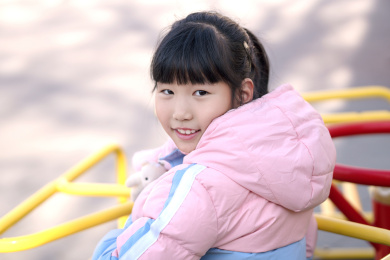 娱乐器材上坐着的小姑娘