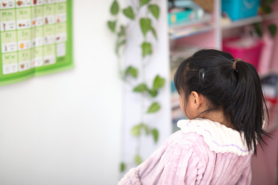 小孩子在学习墙上的英语字母