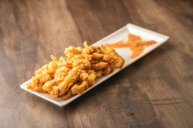 棕色木纹桌面上有一份炸小酥肉