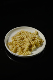 桌面上的盘子里的美味可口的青酱意大利面