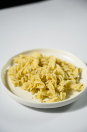 桌面上的盘子里的美味可口的青酱螺丝粉