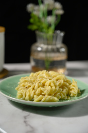 桌面上的盘子里的美味可口的青酱螺丝粉