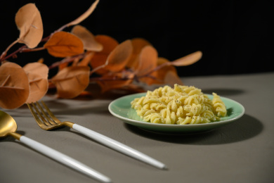 桌面上的盘子里的美味可口的青酱螺丝粉