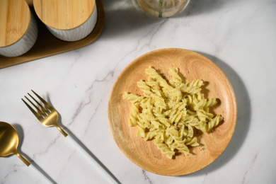 桌面上的盘子里的美味可口的青酱螺丝粉